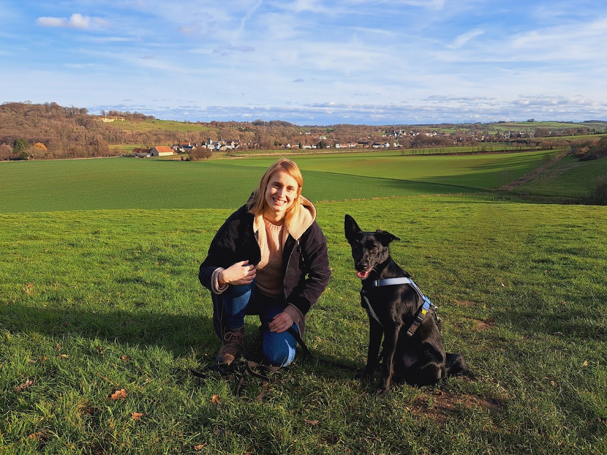 La vétérinaire Céline avec son chien Flo dans un grand champ vert