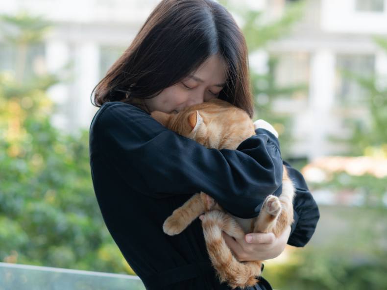 Une femme faisant un câlin à un chat